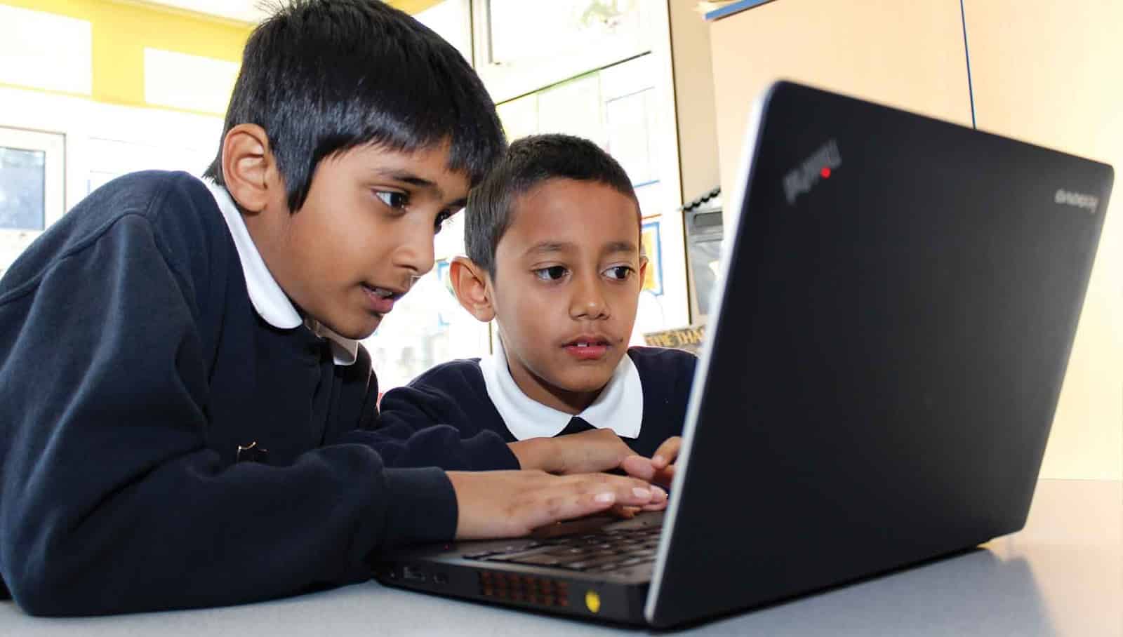 bilgisayar üzerinde çalışan iki çocuk