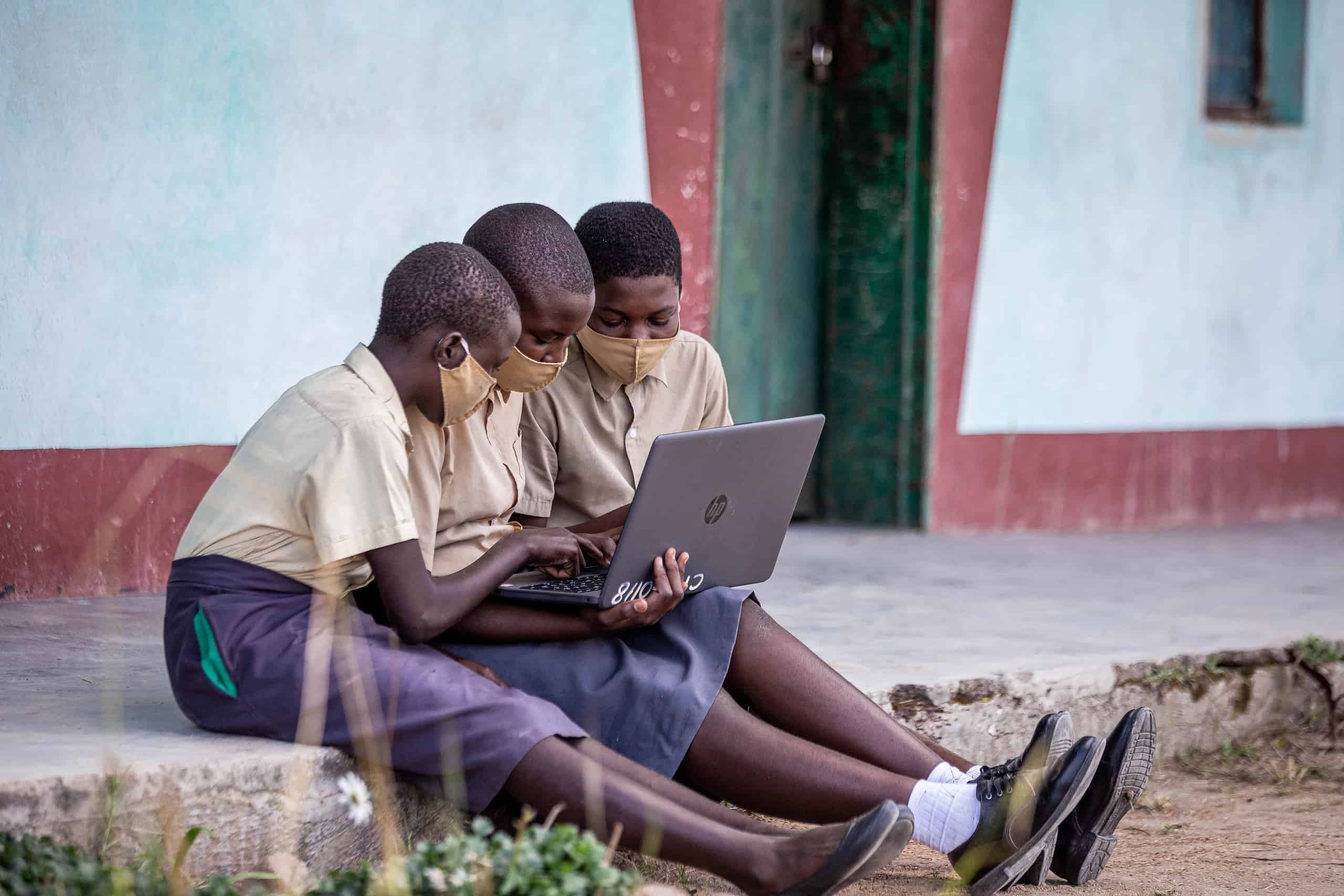 three students with a laptop