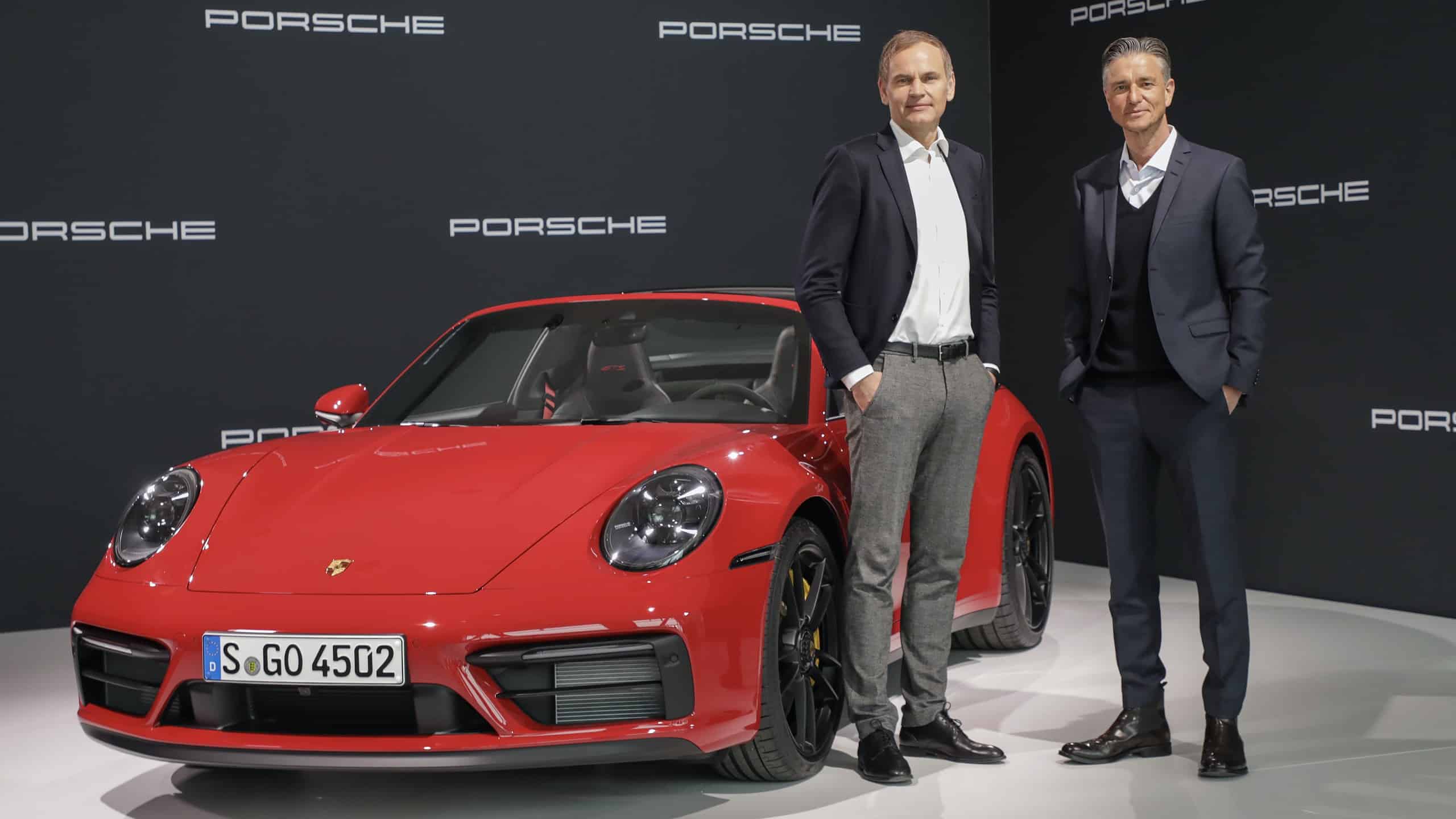 Porsche admins standing next to a Porsche 911 Targa car in 2022 annual meeting event