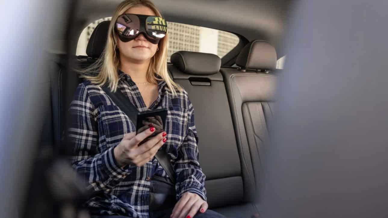 woman wearing Holoride VR goggles inside the car