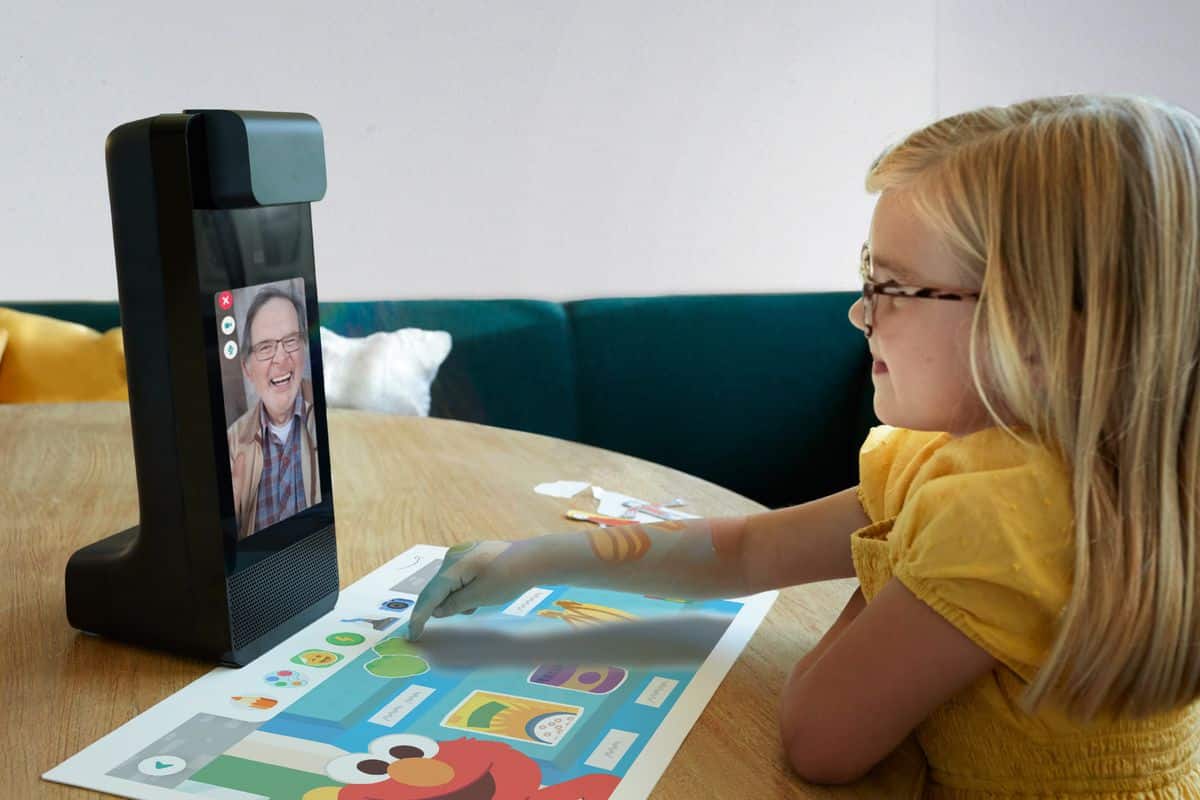 little girl pointing an object being projected by Amazon Glow on projection mat