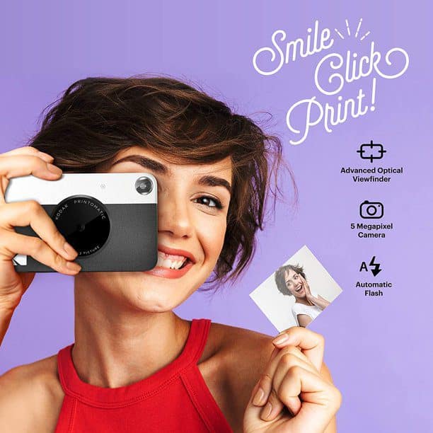 woman in front of violet background peeking through the viewfinder of Kodak Printomatic Instant Camera