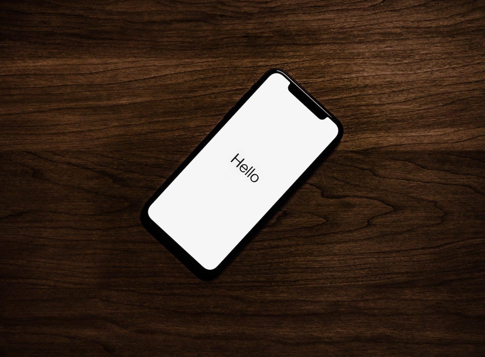 ingeschakeld iPhone bovenop bruin houten oppervlak