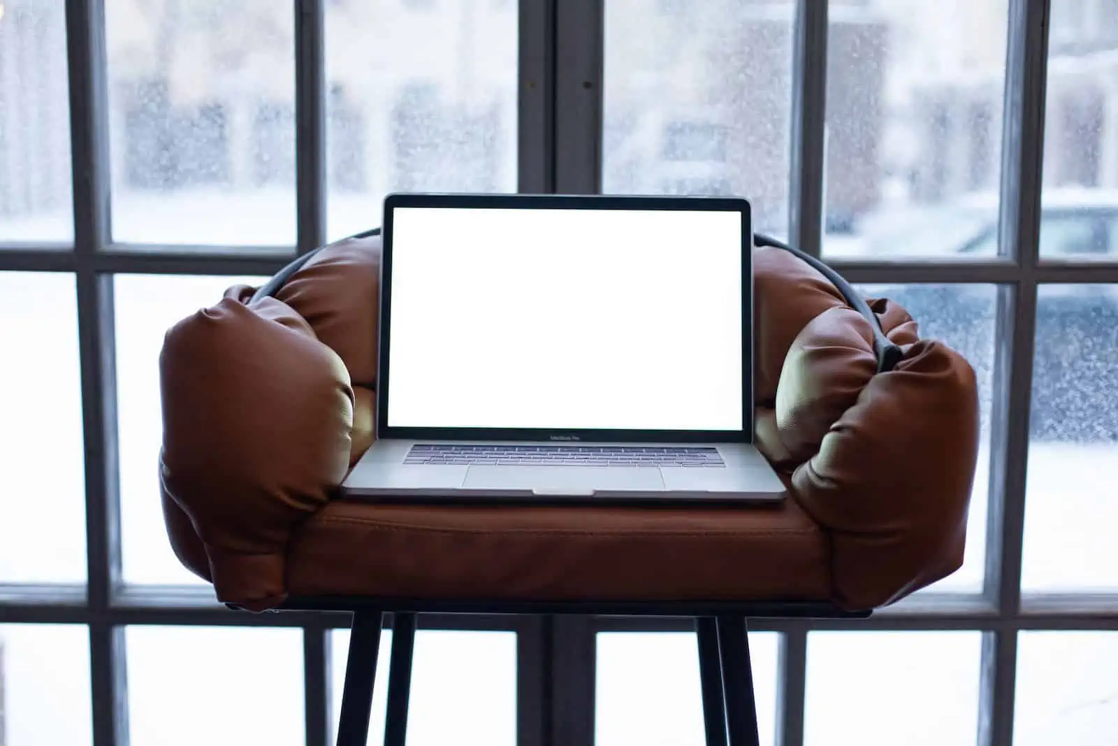 Laptop Lying in an Armchair Standing in front of a Window